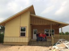 Newly built house with family standing on the porch
