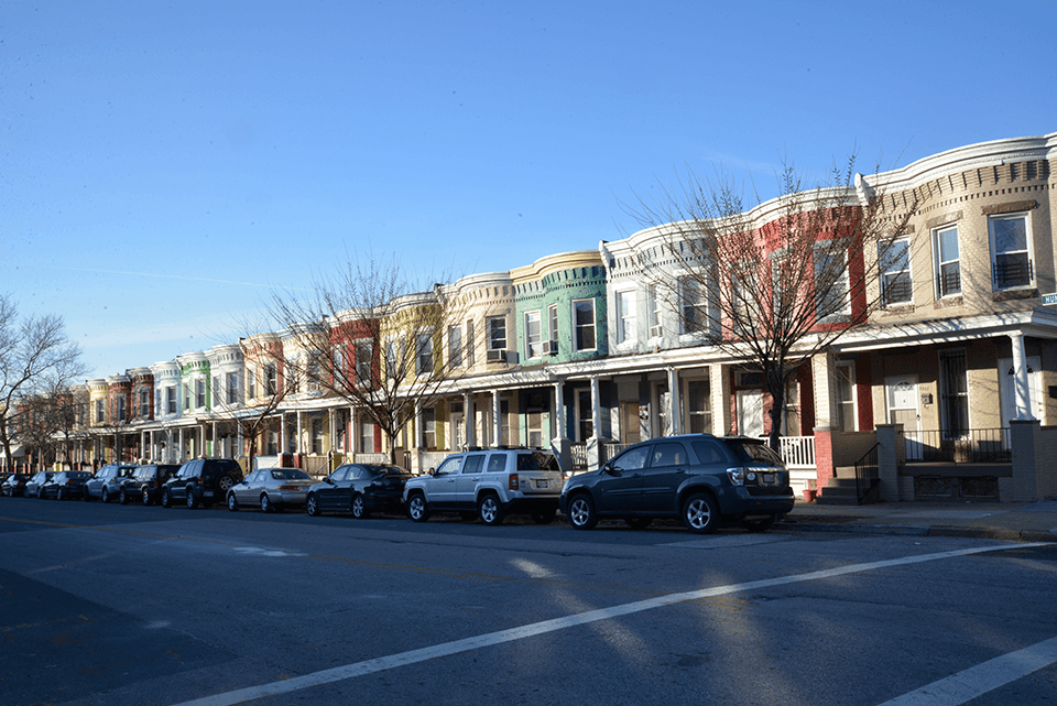 Multi-colored homes line the street of a neighborhood