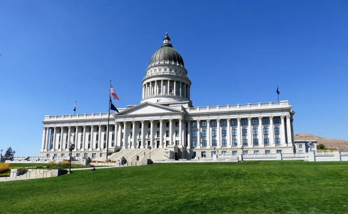 U.S. Capitol Building with green lawn in the foreground and blue sky in the background
