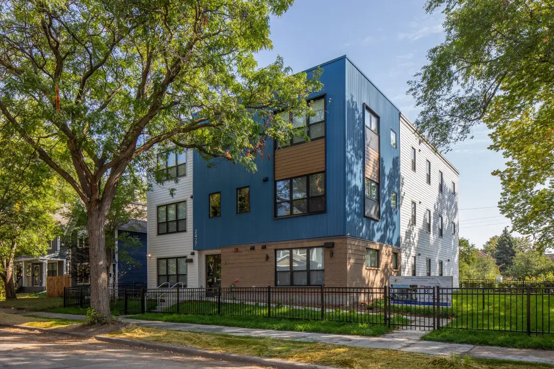 Tree-lined street with mix of small multifamily building adjacent to single-family homes