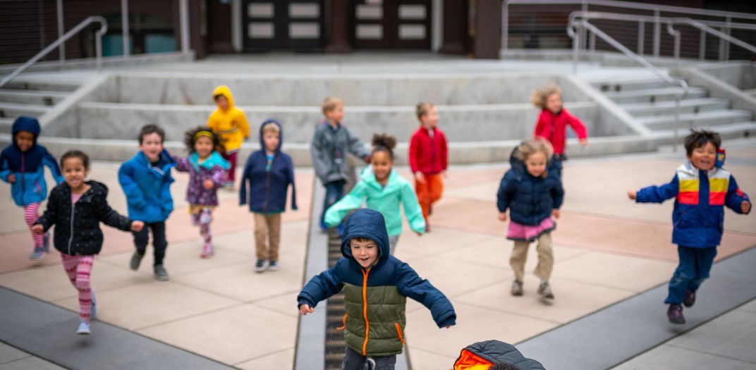 children running and playing in front of a building