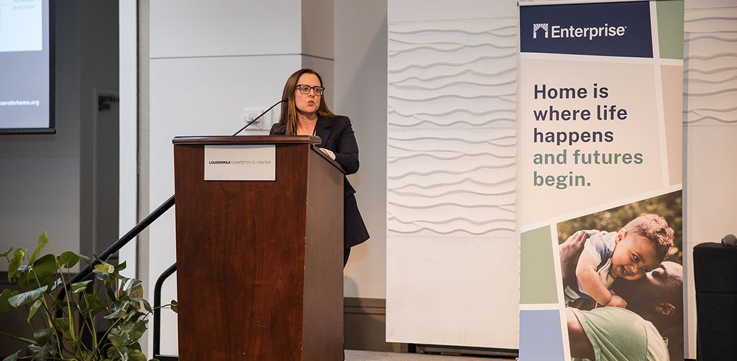 A woman standing at a podium presenting