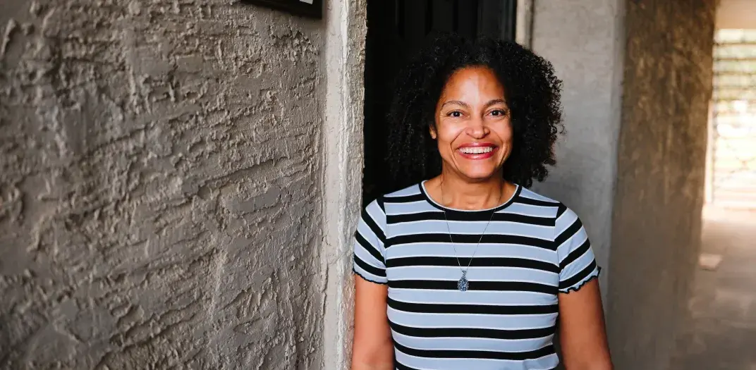 A woman stands in front of the doorway for apartment 1012