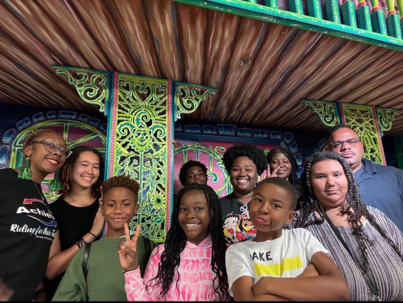 Picture of children and mentor adults having fun, smiling and making faces