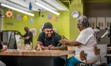 man and woman at a table working on crafts