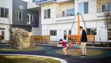 boy skateboarding at a playground with a man watching