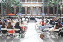 outside venue with people sitting watching a speaker