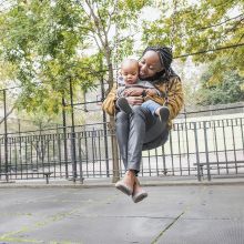 A mother swinging with her child in a park