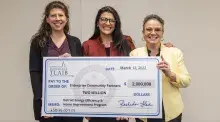 Picture of three women with oversized check