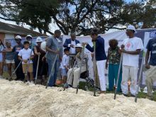 People stand at a groundbreaking for a property in New Orleans