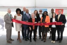 Group of people standing at a ribbon cutting