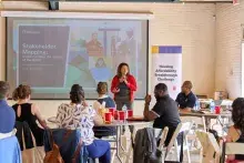 Person standing in front of a room speaking into a microphone