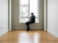Woman sitting in a room on window ledge