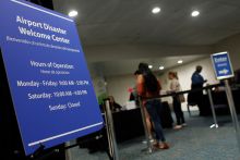 People get information at the Reception Center for Puerto Rican refugees set up at the Orlando International Airport in Orlando, Florida on November 30, 2017.