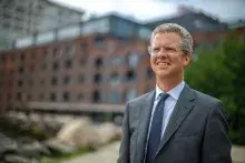 A photo of Shaun Donovan smiling and looking off in the distance