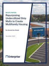 Repurposing Underutilized Strip Malls to Create Multifamily Housing and a parking lot in front of a store