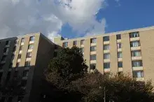 Trees shade the buildings of Lake Anne House in Reston, Virginia with clouds in the sky