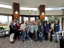 A group of people standing in front of a bay of windows