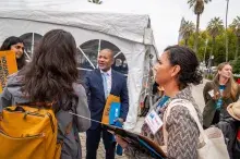 Man in suit shaking hands with a woman who has back to camera