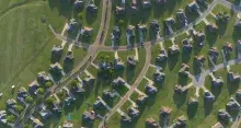 An aerial view of single-family homes and green lawns
