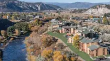 Aerial photo of Eagle Villas with a river and mountains in the background