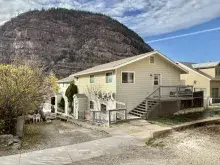 Streetview of Ouray Property, a yellow apartment building, with a hill in the background