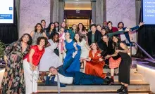 Smiling people in brightly colored, festive clothing playful posing for a group photo 