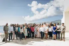 Enterprise U.S. Caribbean team and U.S. Virgin Islands Housing Ecosystem Development Grant Program grantees outside with the ocean and hillside in the background