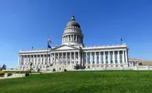 U.S. Capitol Building with green lawn in the foreground and blue sky in the background