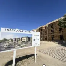 Tracy Apartments under construction with signage of its rendering in the foreground