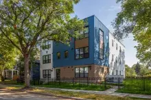 Tree-lined street with mix of small multifamily building adjacent to single-family homes