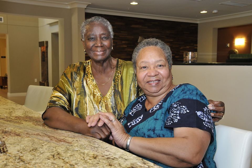 Two senior women posing for the picture smiling.
