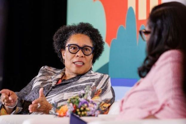 U.S. Department of Housing and Urban Development Secretary Marcia Fudge seated and speaking to another woman