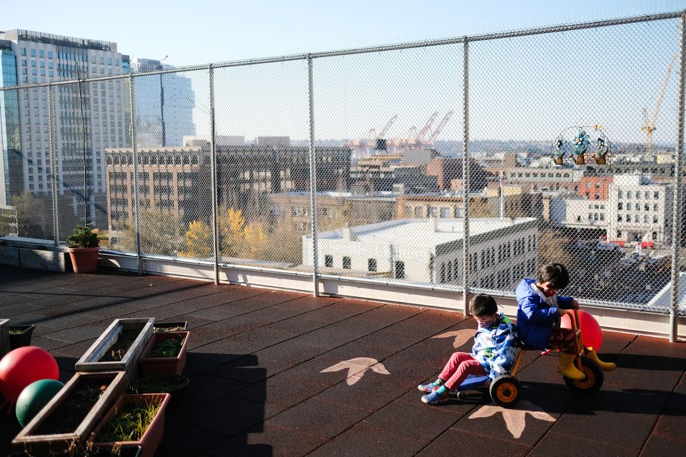 Children playing on the roof of Hirabayashi Place overlooking the city