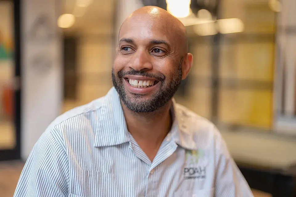 A man sitting and looking into the distance smiling