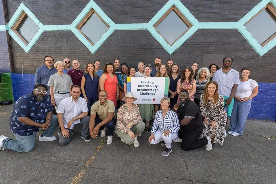 A group of people holding a sign that says Housing Affordability Breakthrough Challenge 