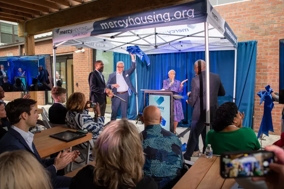 Attendees view a ribbon being cut at a ceremony 