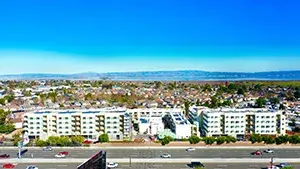 Aerial view of apartment buildings with a community and mountains in the background