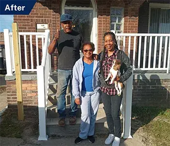 A family stand on the newly built steps of their home in Detroit.