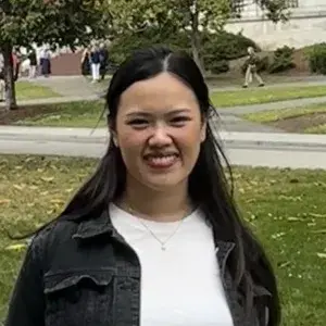 Smiling woman in dark jacket and white shirt with long dark hair