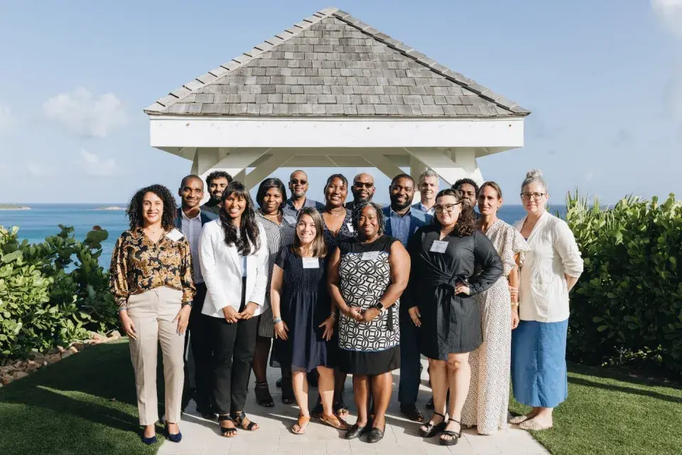 Enterprise U.S. Caribbean team and grantees of the U.S. Virgin Islands Housing Ecosystem Development Grants Program together in front of a gazebo overlooking the ocean 