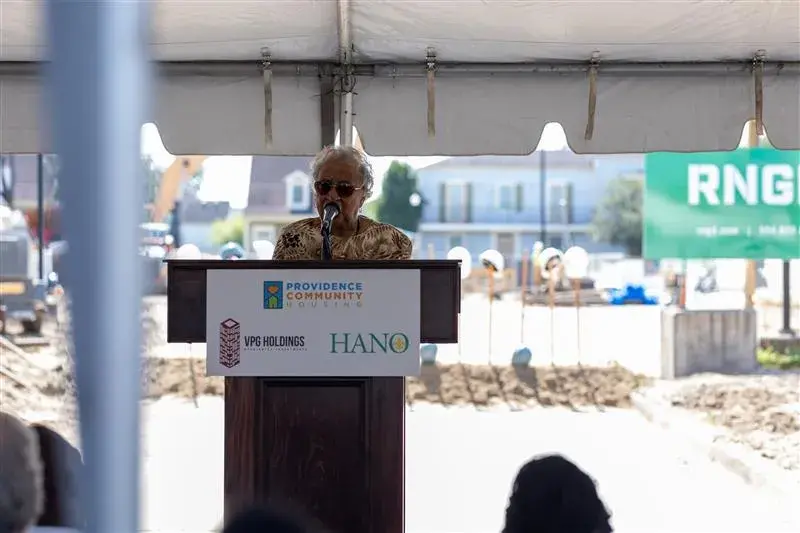 Emelda Paul speaks from a podium at a groundbreaking ceremony