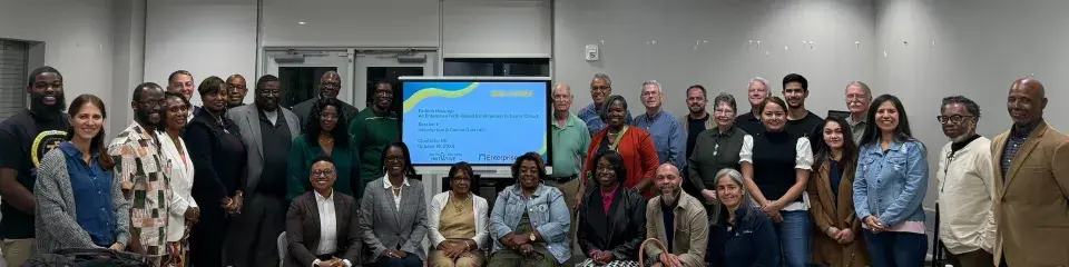 Members of the Enterprise FBDI Charlotte Cohort stand together by a screen 