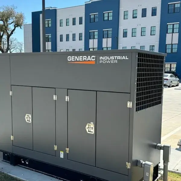 Generator with blue and white multifamily housing development in the background