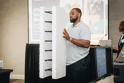 A man holds a sample alternative construction form during the 2026 U.S. Virgin Islands Affordable Housing Workshop