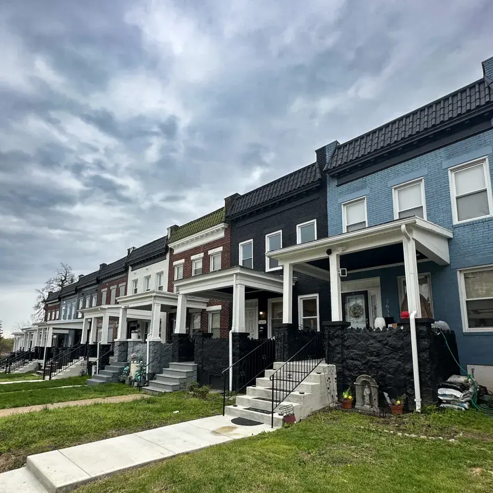 Row of older well-maintained townhomes with front porches