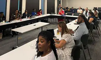Panelists sit at tables arranged in a u-shape at the USVI Affordable Housing Workshop