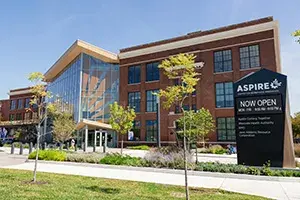 Aspire Center for Workforce Development's building from the street with trees lining the sidewalk