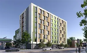 Streetview of Casa Yucatan, an 8-story building, with trees lining the building and cars driving by