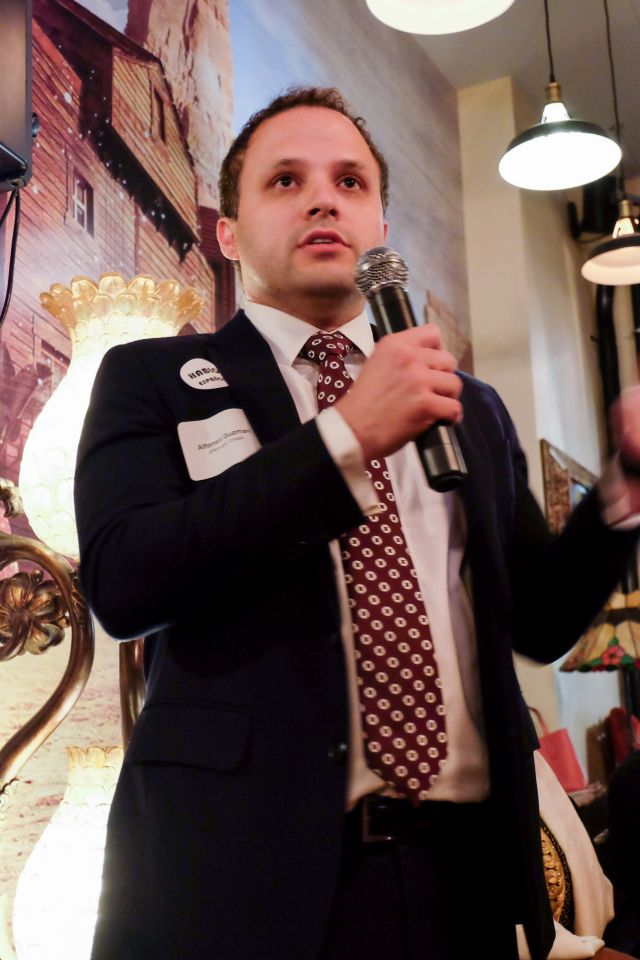 Alfonso Guzman speaks into a handheld microphone